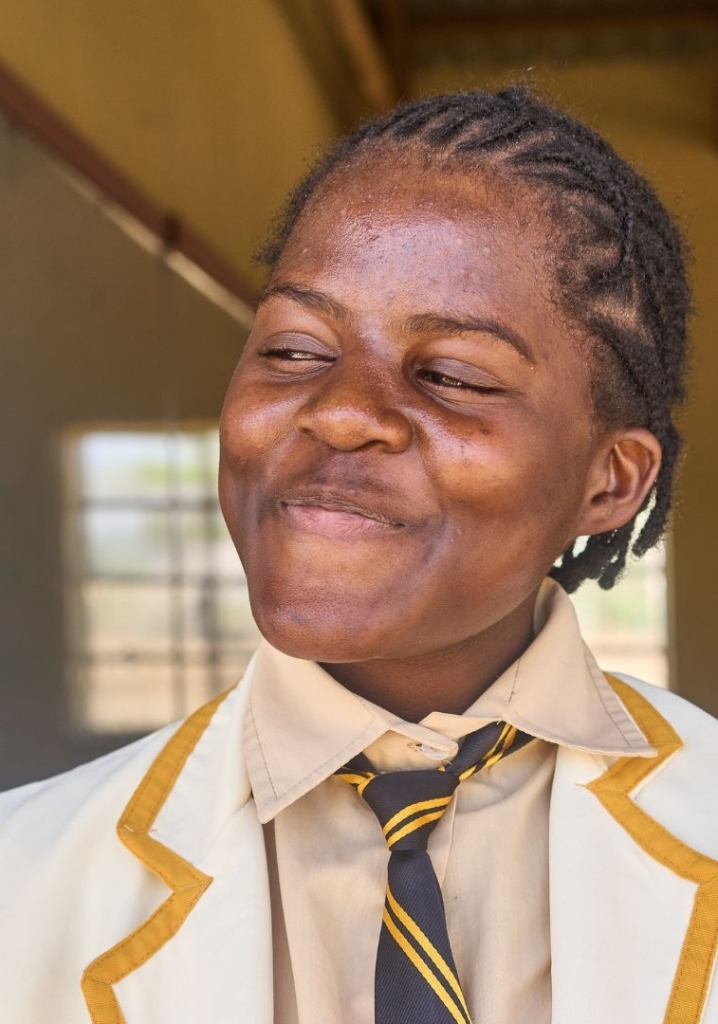 Ragazza ugandese in divisa scolastica che sorride